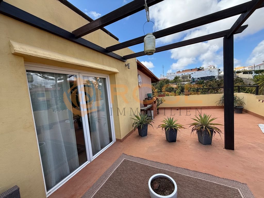 Überdachter Außenbereich mit eleganter Pergolenkonstruktion und großflächiger Terrassenfläche