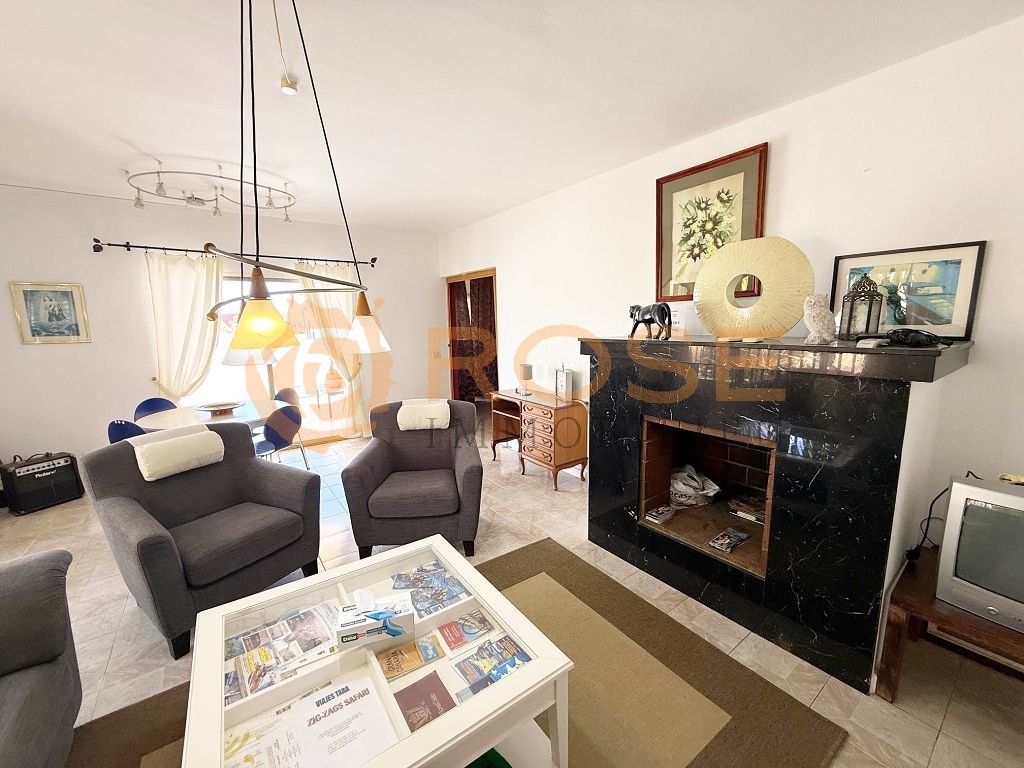 Elegantes Wohnzimmer mit offener Raumstruktur und dekorativer Kaminanlage mit Marmorfassade