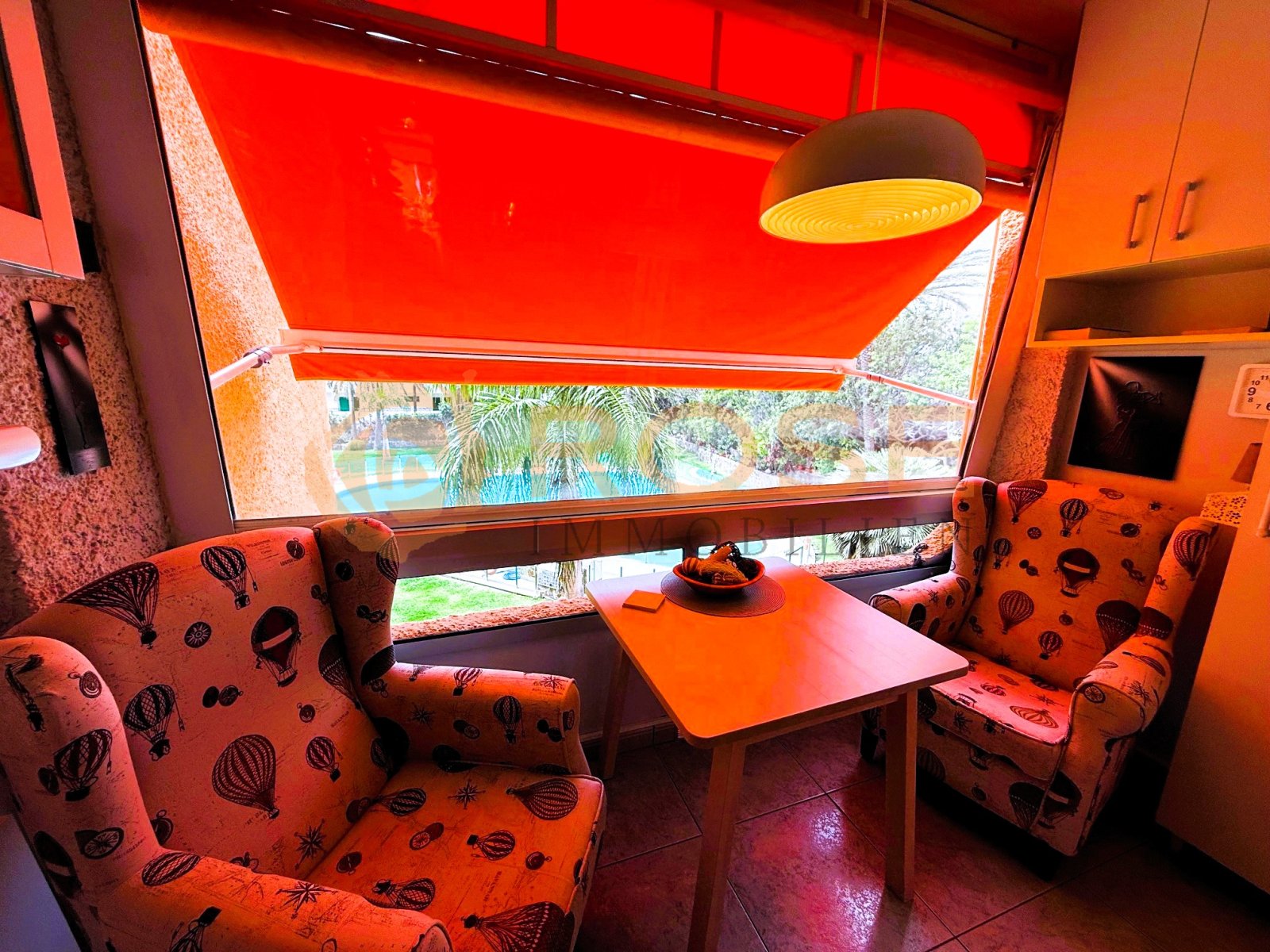 Wohnzimmer mit Panoramafenster und Poolblick