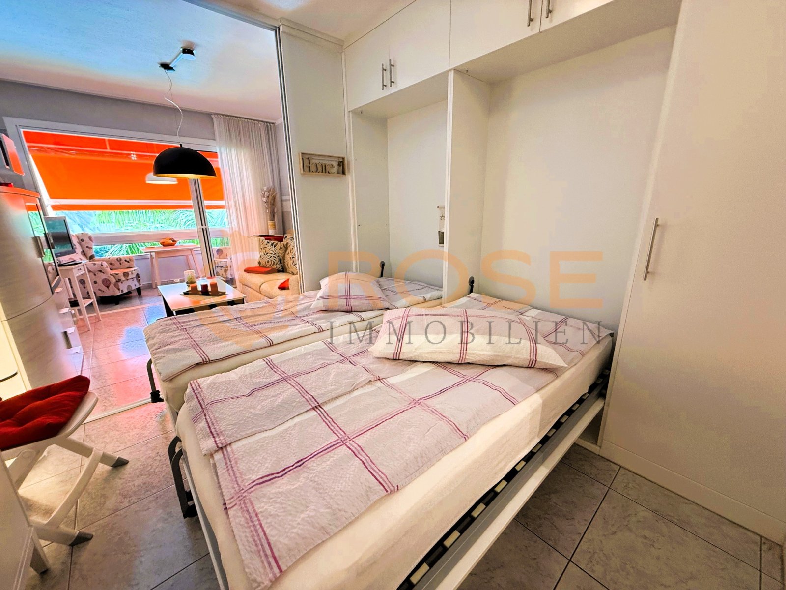 Schlafzimmer mit begehbarem Kleiderschrank und fließendem Übergang zum Wohnbereich