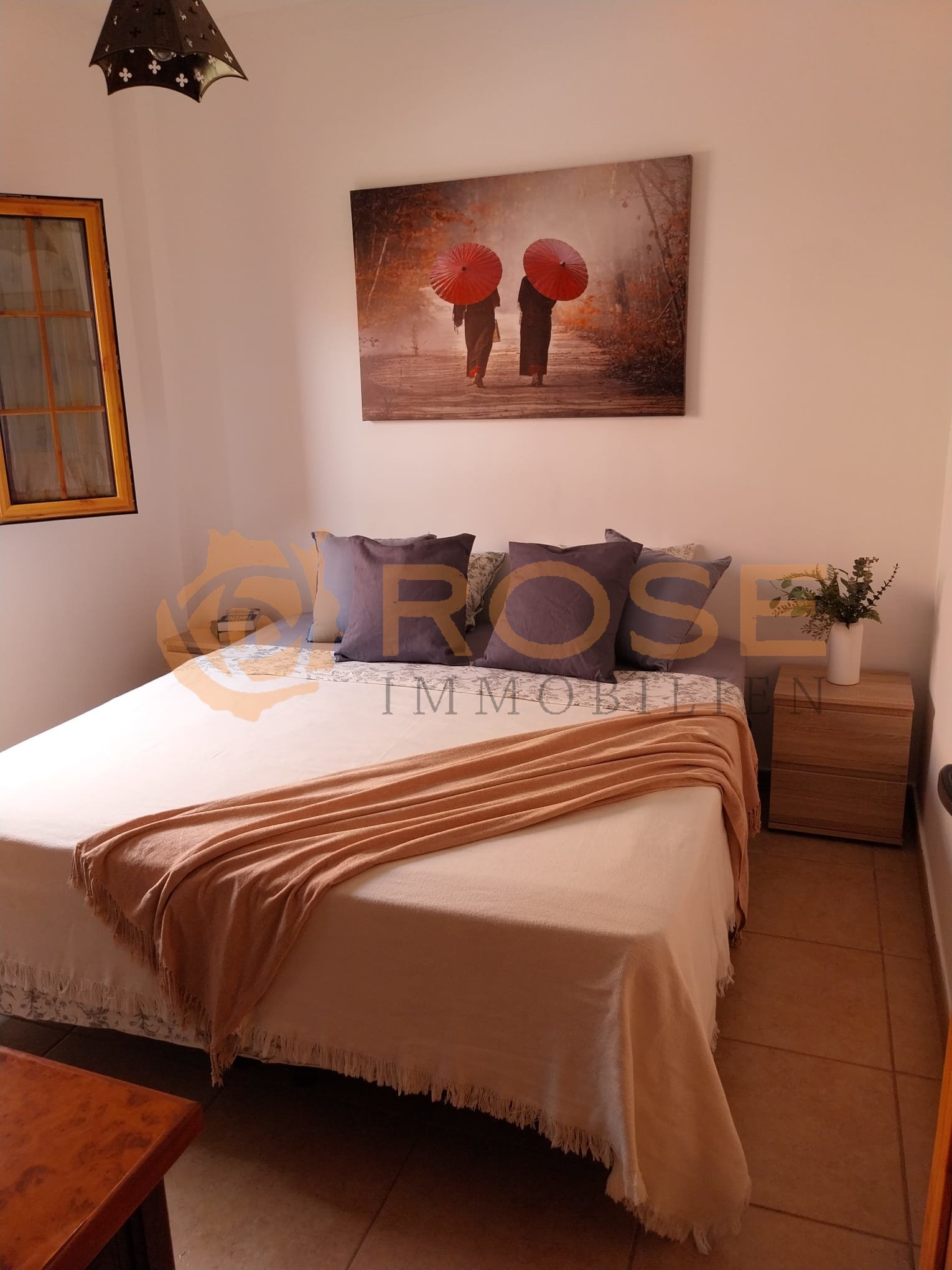 Gemütliches Schlafzimmer mit bodentiefem Fenster und Terrakotta-Fliesenbelag