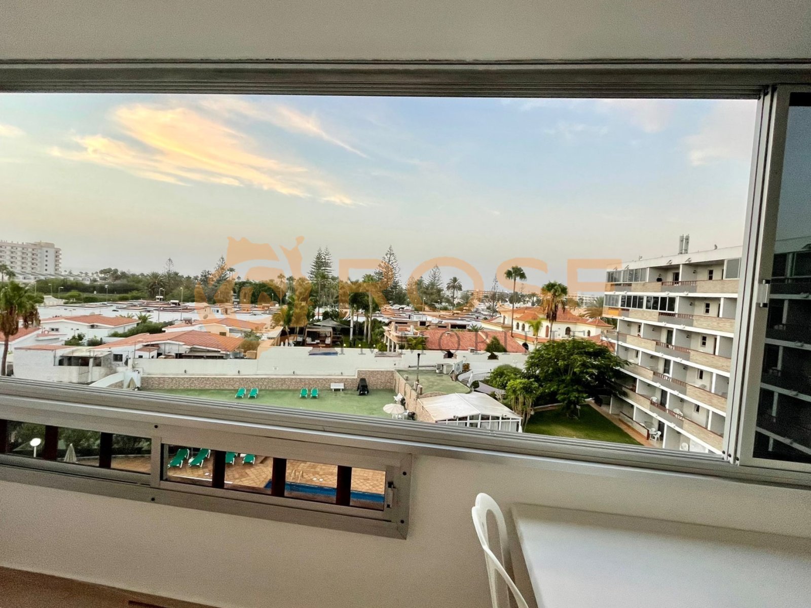 Panoramafenster mit weitem Ausblick über die Poolanlage und Umgebung