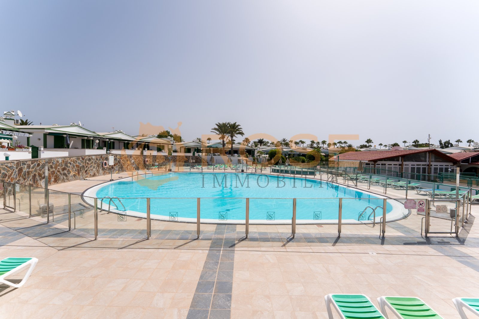 Erfrischende Poolanlage mit großflächiger Liegefläche und professioneller Sicherheitsausstattung Erfrischende Poolanlage mit großflächiger Liegefläche und professioneller Sicherheitsausstattung