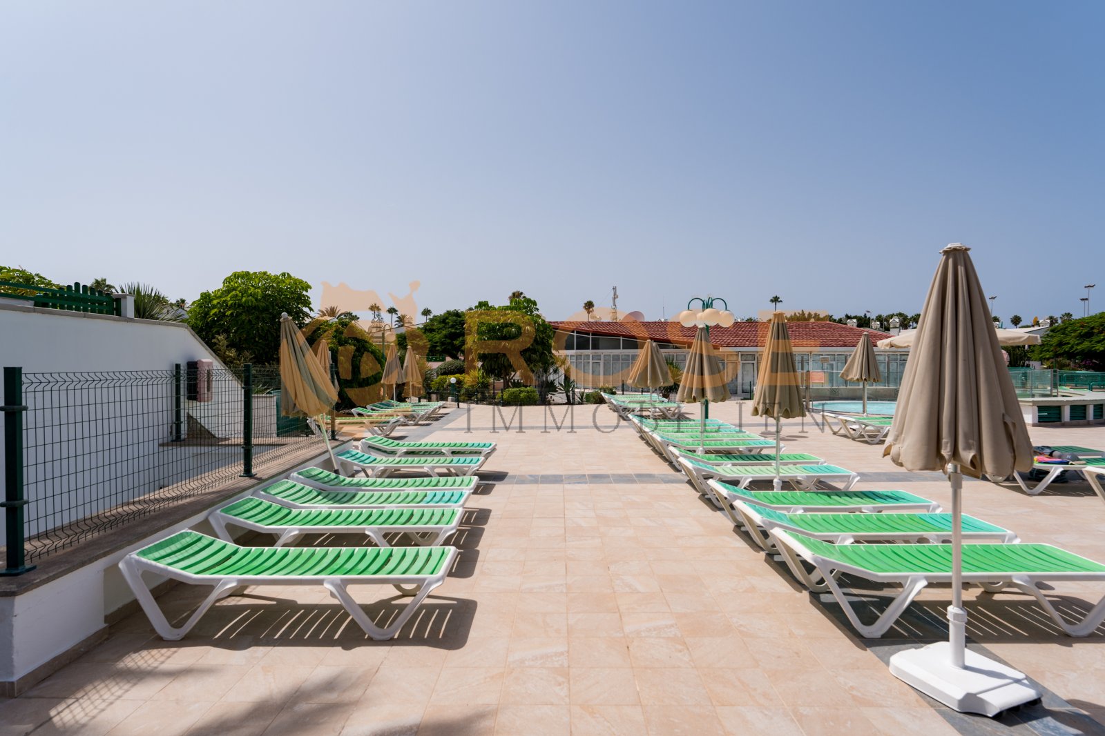 Sonnenverwöhnte Poolterrasse mit professionellen Sonnenschutzanlagen und großflächigen Liegenbereichen Sonnenverwöhnte Poolterrasse mit professionellen Sonnenschutzanlagen und großflächigen Liegenbereichen