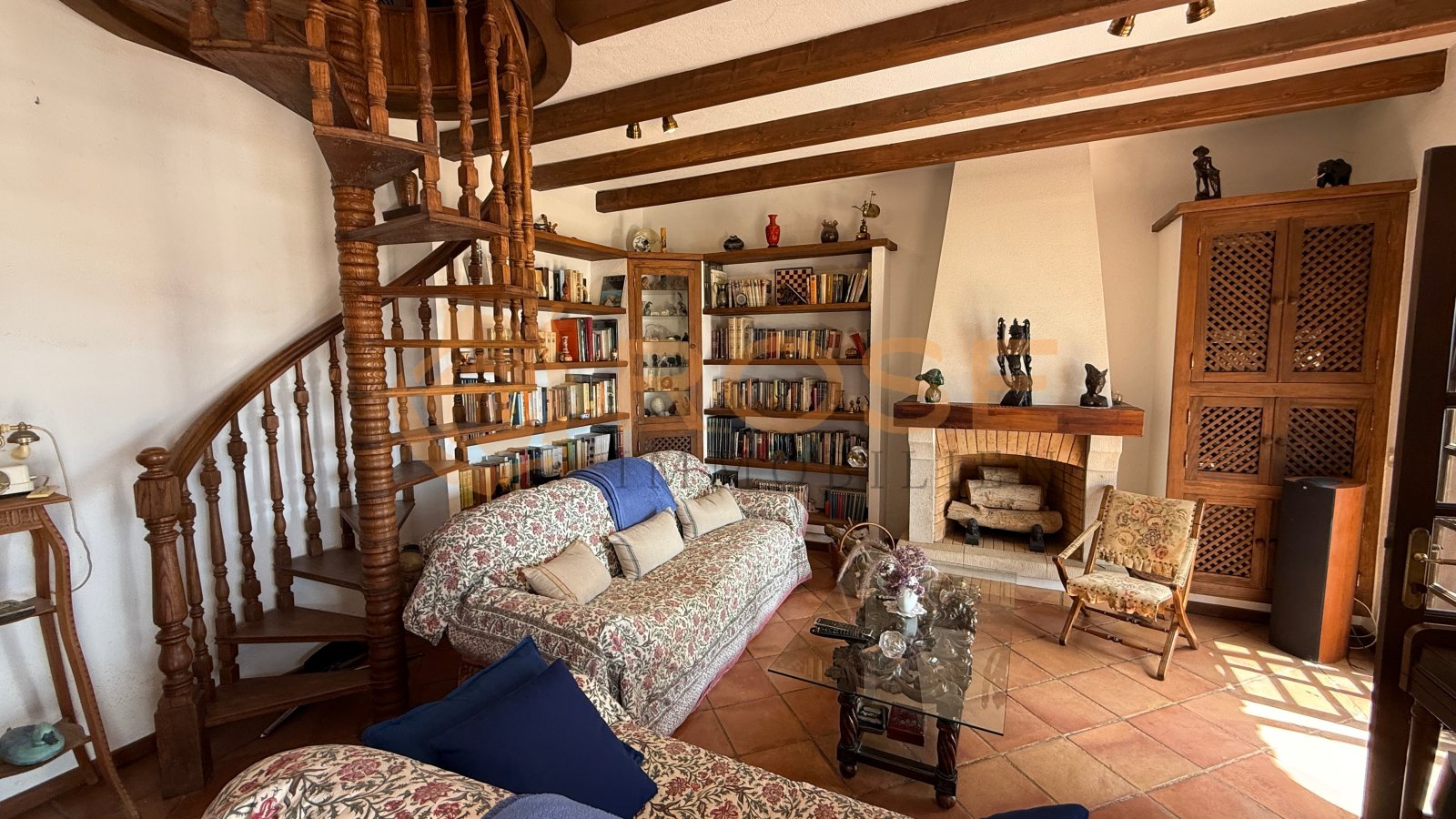 Mehrzweck-Schlafzimmer mit Kaminofen, Holzbalkendecke und integrierter Wendeltreppe