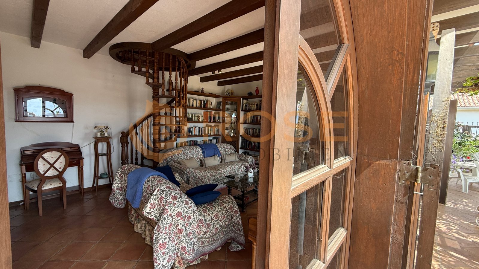 Schlafzimmer mit charaktervoller Wendeltreppe, eingebauten Bücherregalen und Zugang zur Terrasse