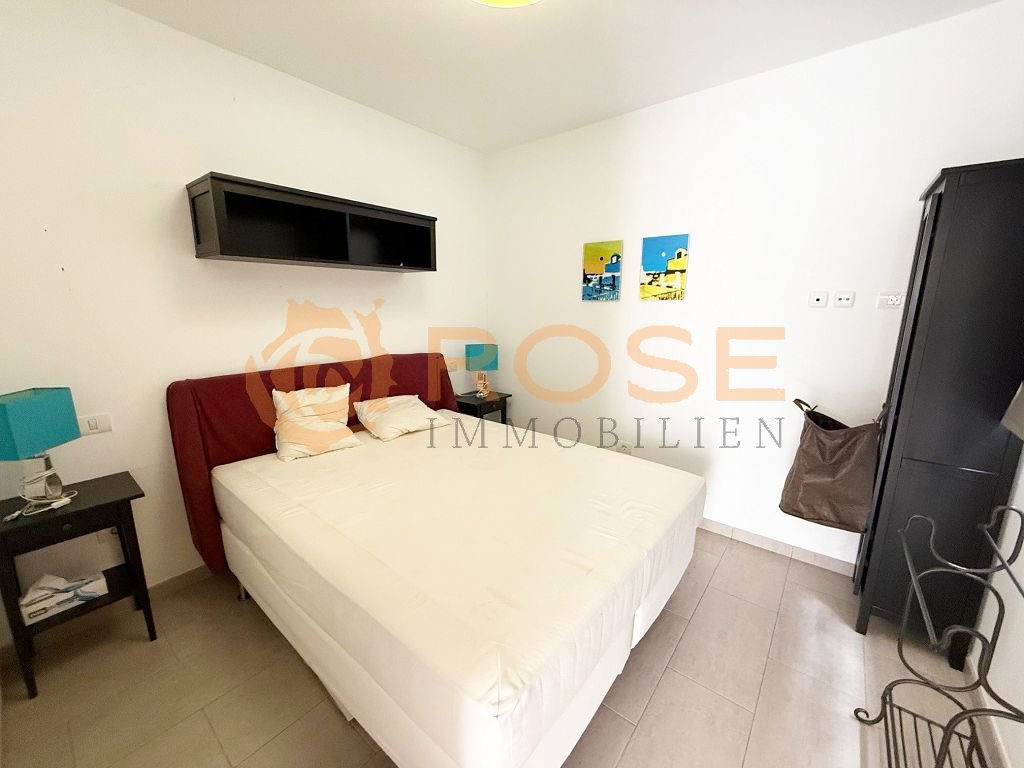 Comfortable bedroom with wall-mounted air conditioning and practical power outlets.