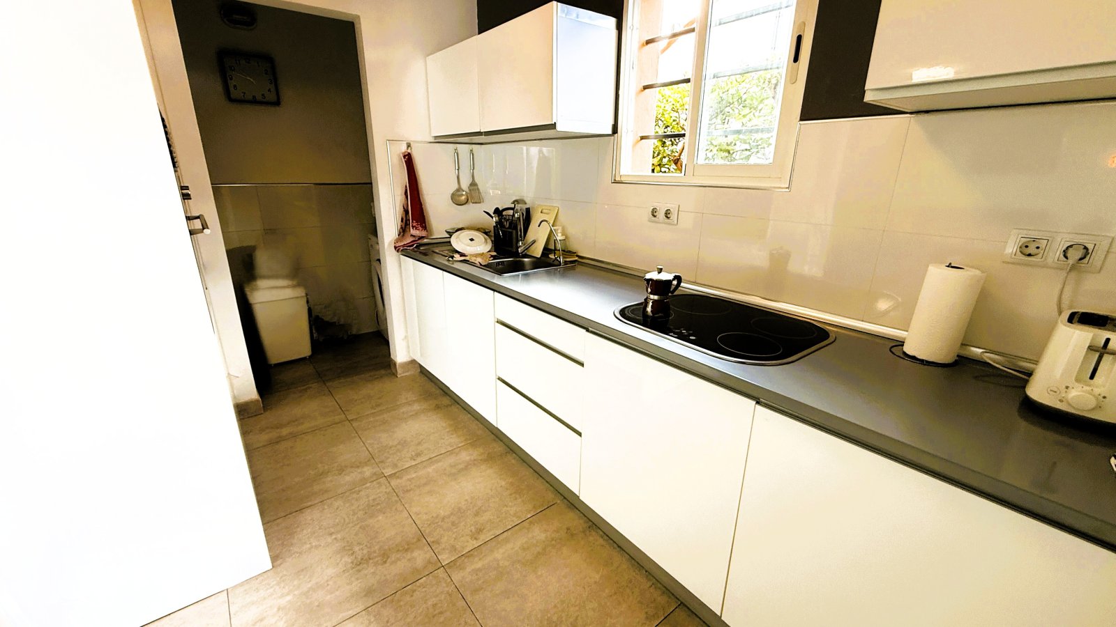 Functional kitchen with continuous work surface and natural lighting