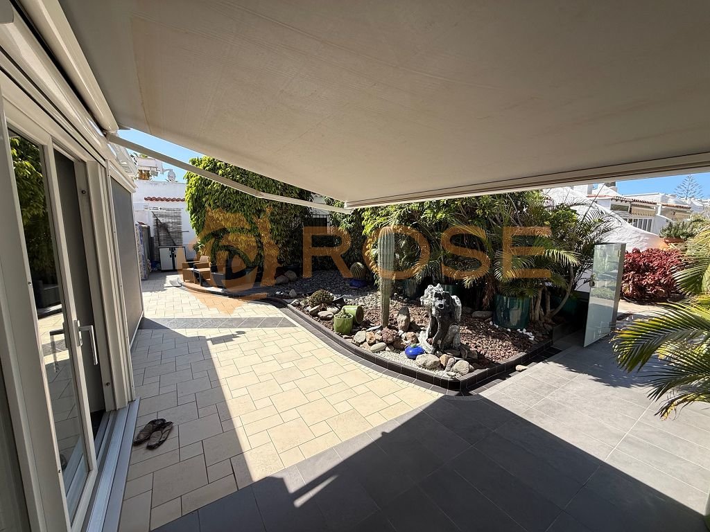 Terrace area with motorized awning and landscaped garden design