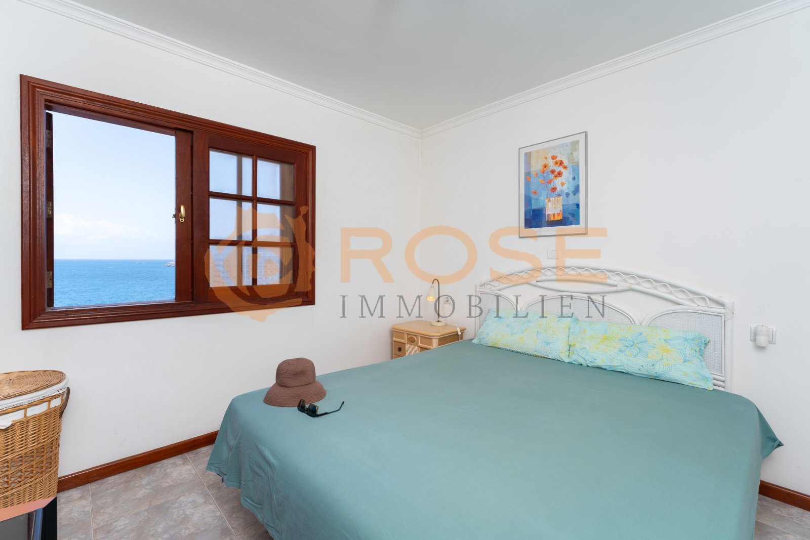 Bedroom with panoramic sea view through large window and high-quality wooden frame