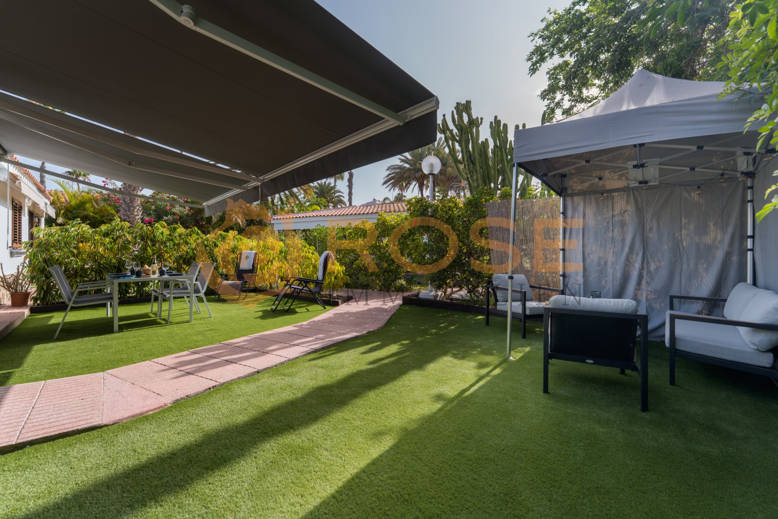 Terrace area with motorized awning and flexible shading structures Terrace area with motorized awning and flexible shading structures