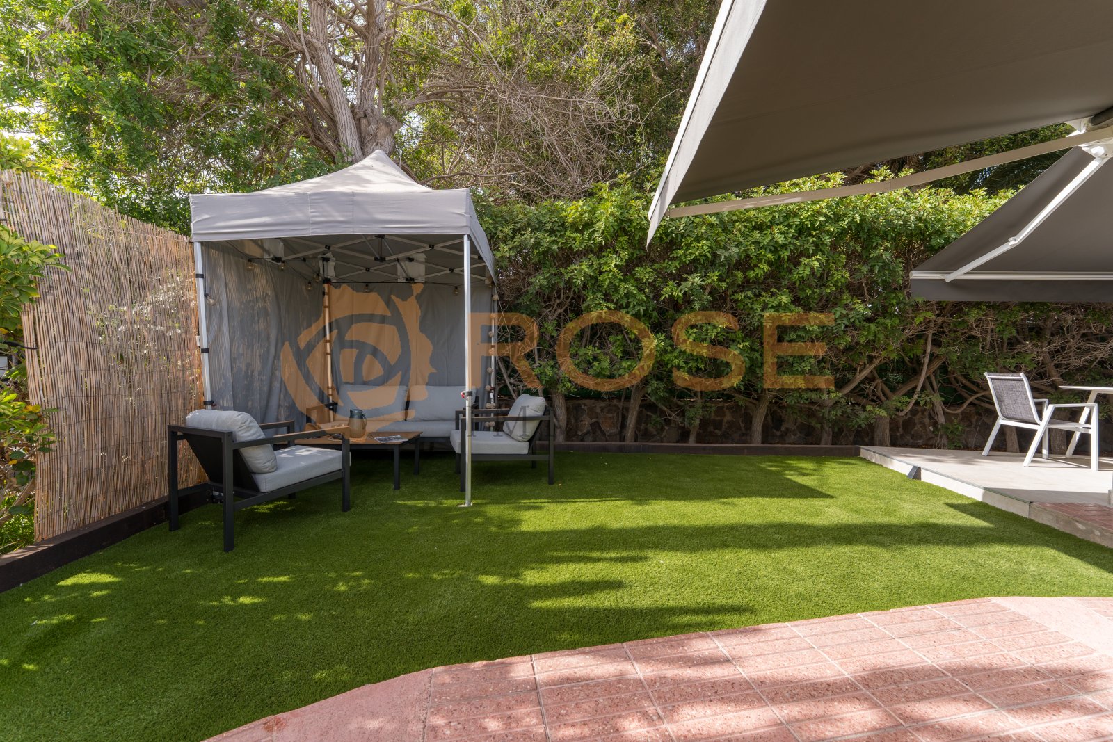 Private garden with artificial grass and flexible shade structures Private garden with artificial grass and flexible shade structures