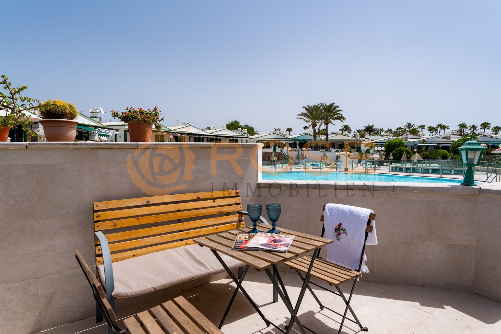 Sunny rooftop terrace with pool view and surrounding balustrade Sunny rooftop terrace with pool view and surrounding balustrade