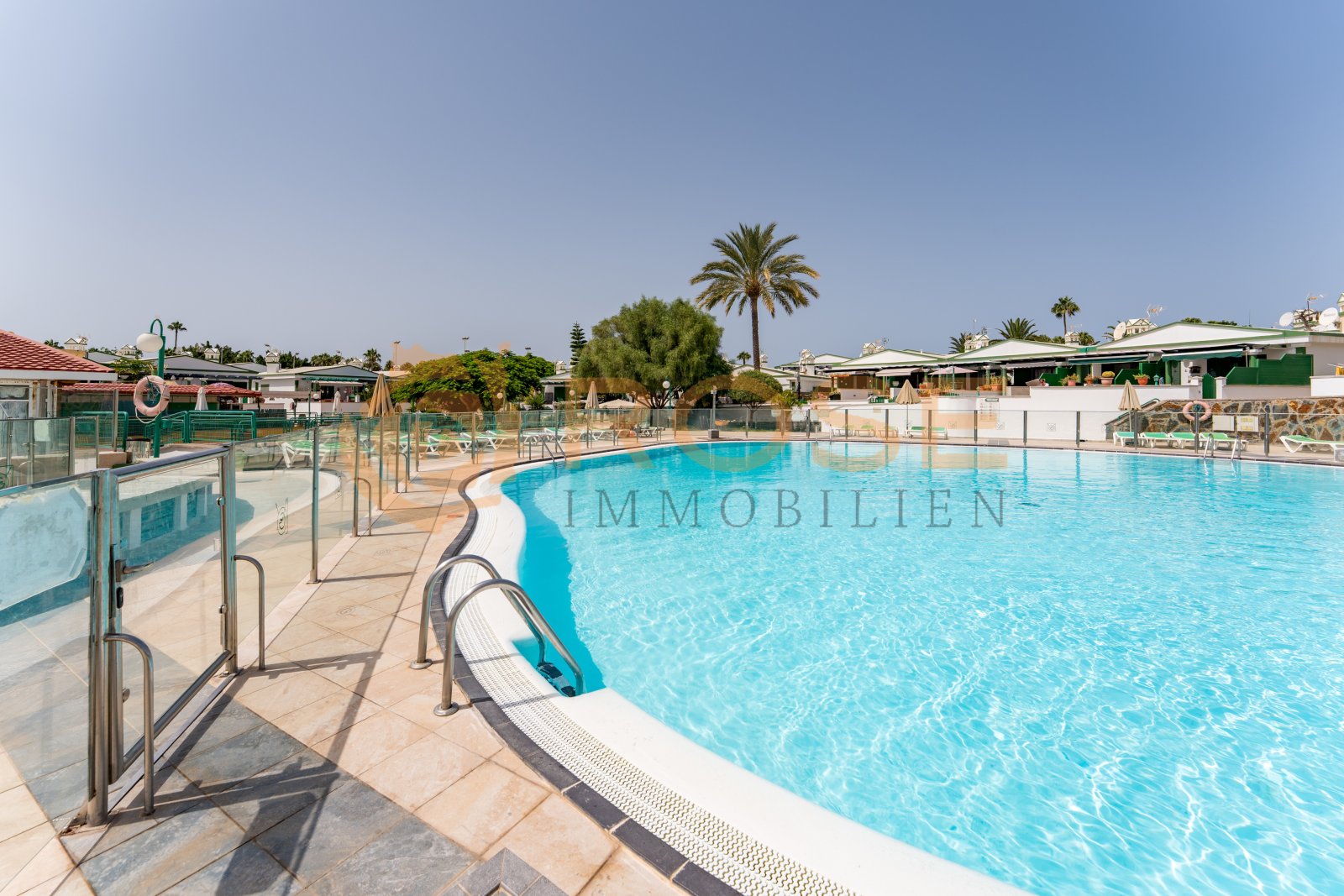 Spacious pool area with modern safety features and well-maintained outdoor space Spacious pool area with modern safety features and well-maintained outdoor space
