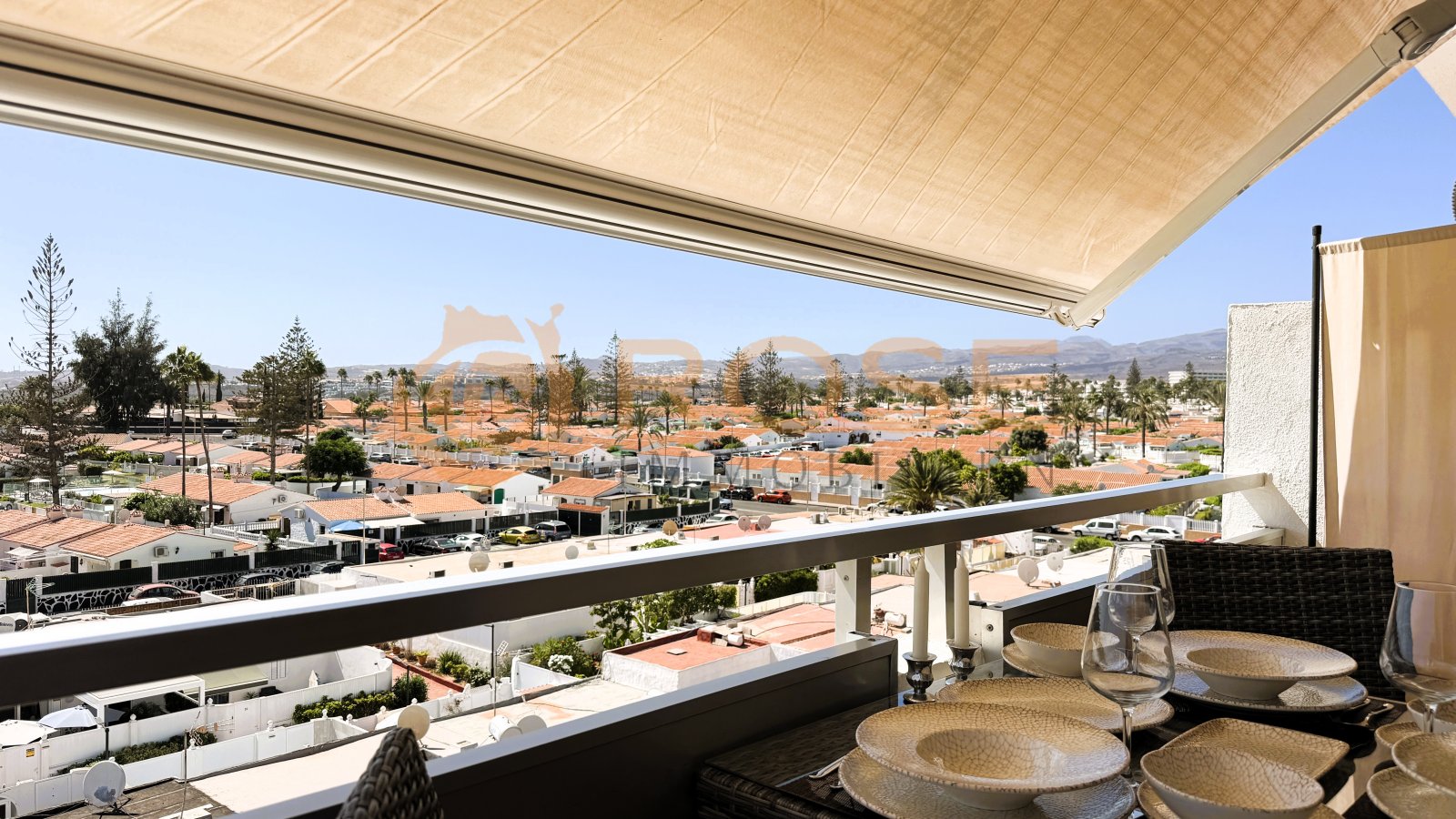 Terrace area with motorized awning and panoramic view of the coastal landscape