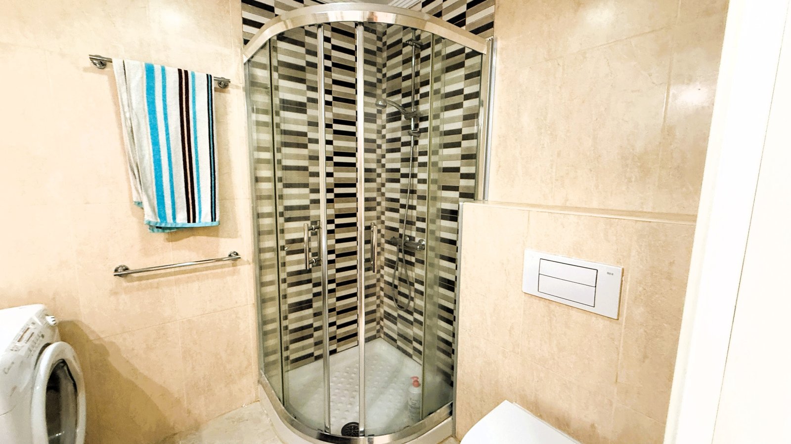 Modern bathroom with walk-in shower and practical washing machine integration Modern bathroom with walk-in shower and practical washing machine integration