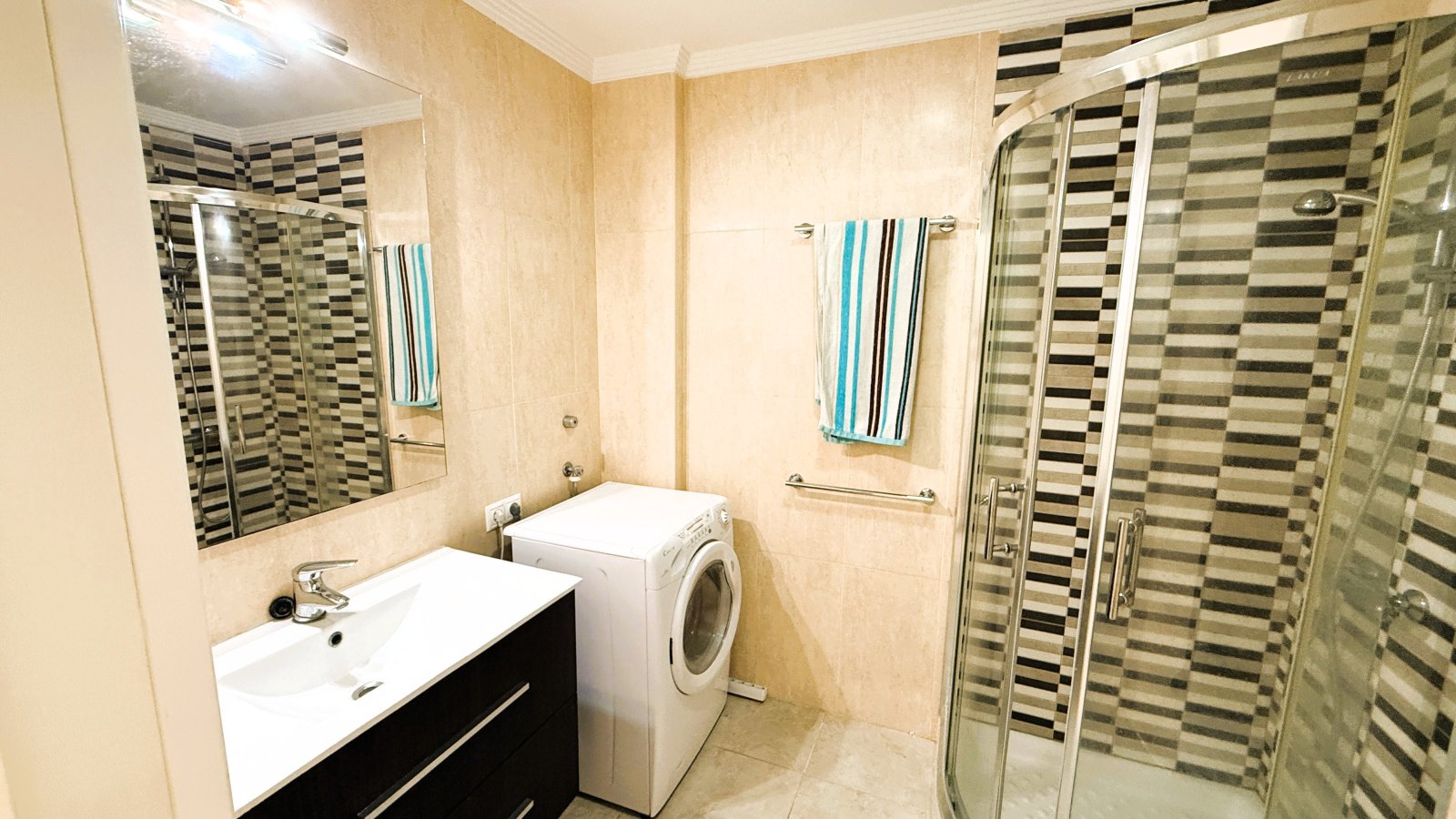 Modern bathroom with integrated washing machine and walk-in shower cabin Modern bathroom with integrated washing machine and walk-in shower cabin