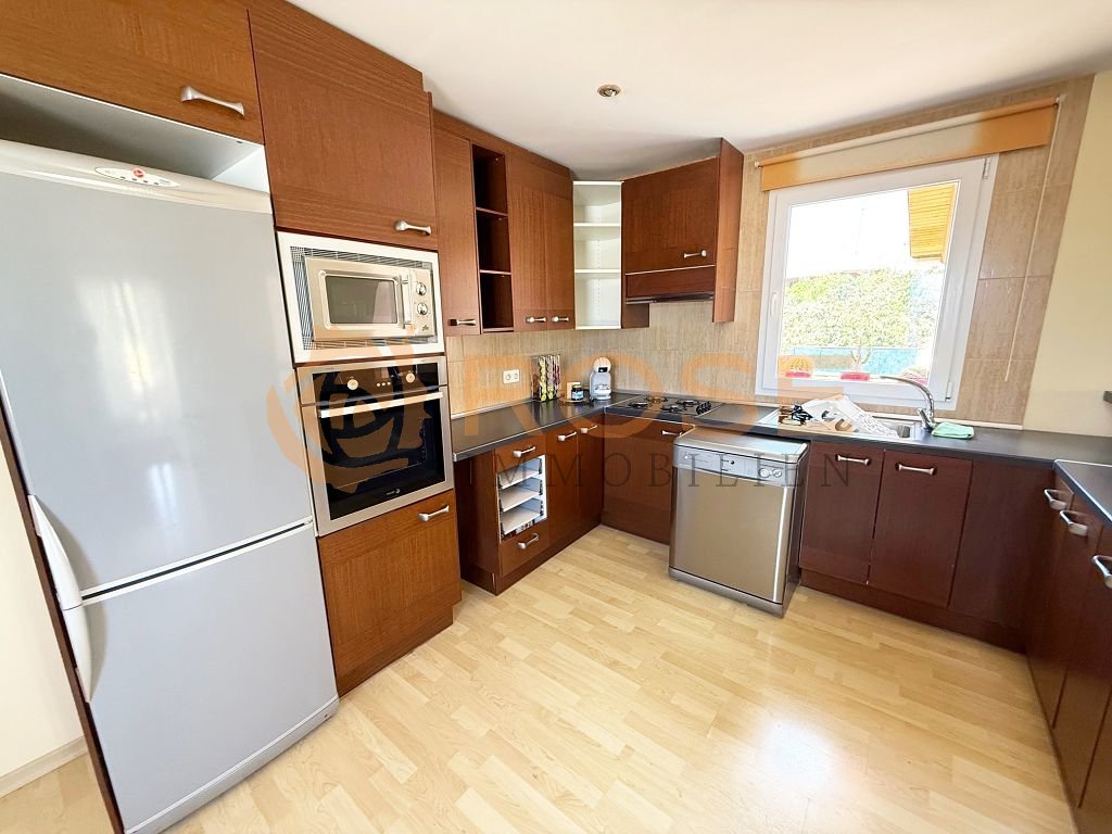 Cocina moderna con distribución en forma de L funcional y equipamiento de electrodomésticos empotrados de alta calidad