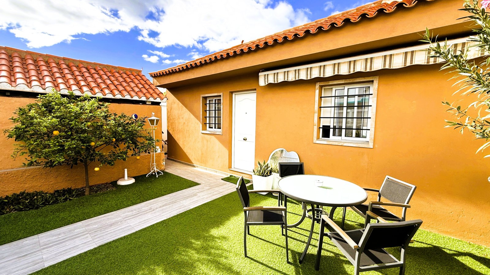 Hermoso exterior con césped cuidado, terraza cubierta y conexión directa a la casa