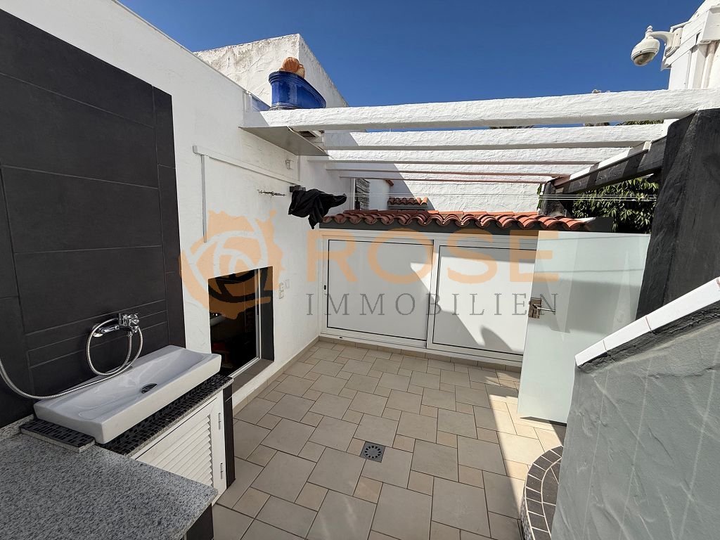 Área de terraza con ducha integrada y pérgola cubierta Área de terraza con ducha integrada y pérgola cubierta