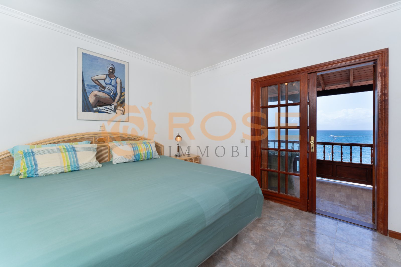 Dormitorio principal con elegidas puertas correderas de madera y acceso inmediato a vistas al mar