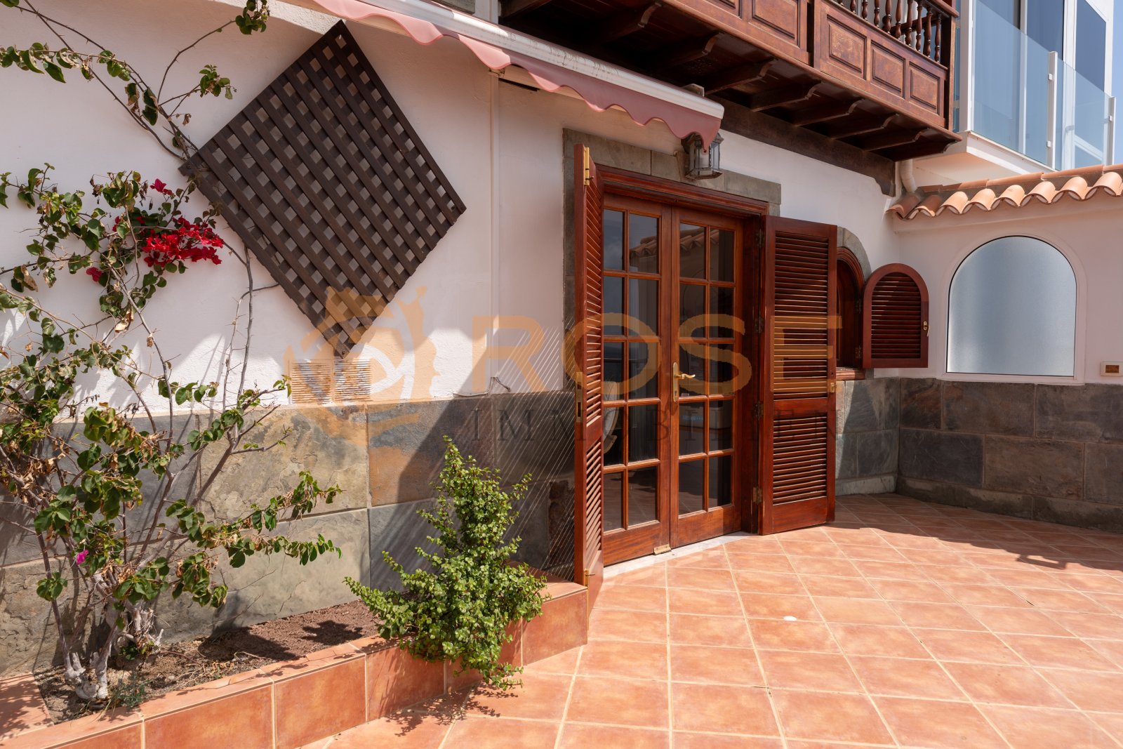 Área de terraza con puertas correderas de madera de alta calidad y protección contra el viento integrada – su espacio exterior protegido