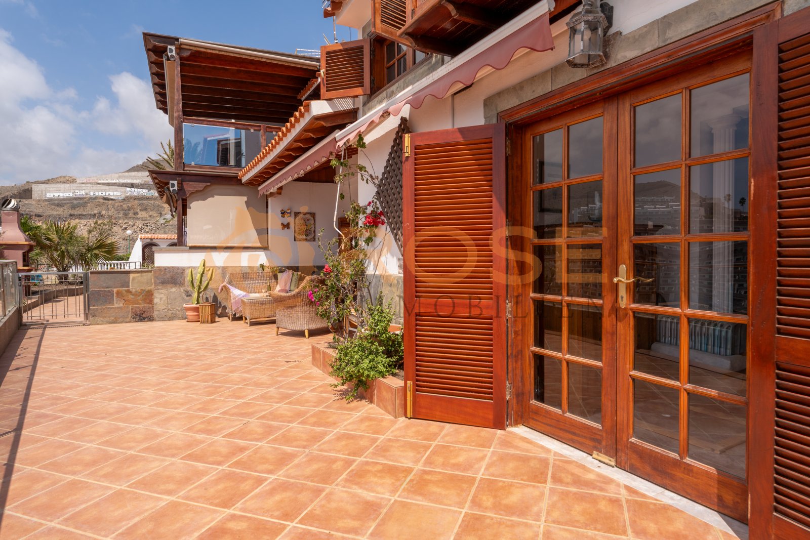 Terraza soleada con puertas correderas de vidrio de alta calidad y pérgola integrada