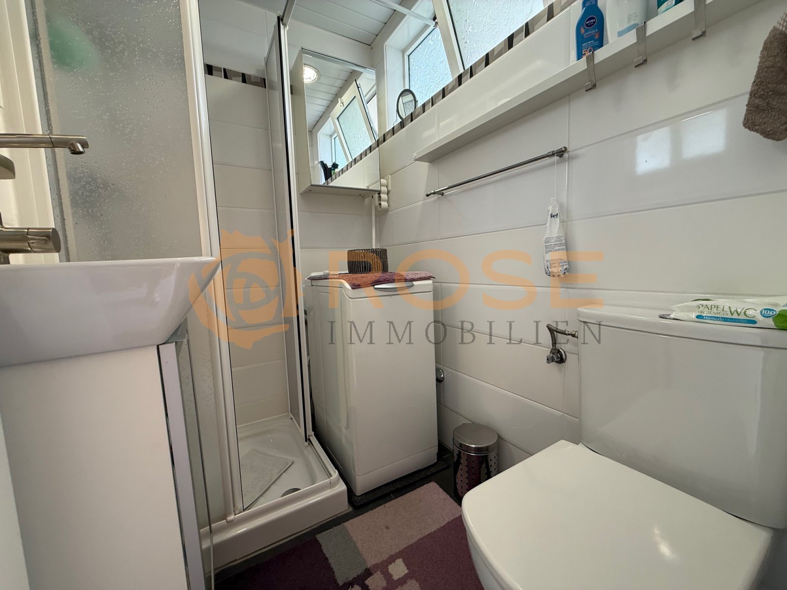 Baño moderno con ducha a nivel del suelo y almacenamiento práctico