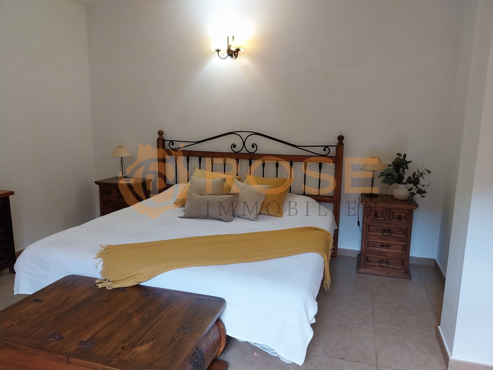 Habitación luminosa con lámpara de pared y suelo de baldosas de terracota