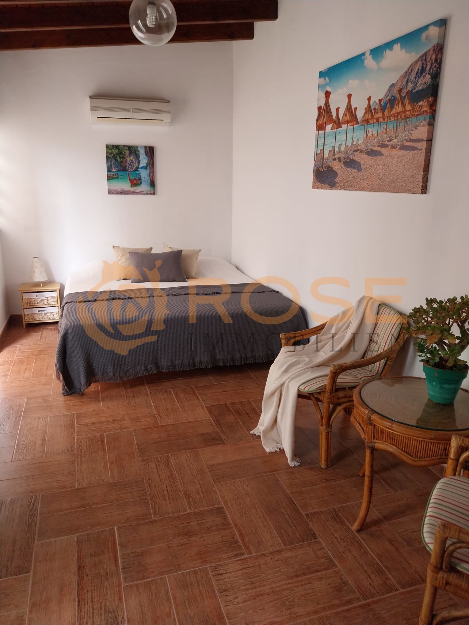 Dormitorio luminoso con aire acondicionado y techo de vigas de madera