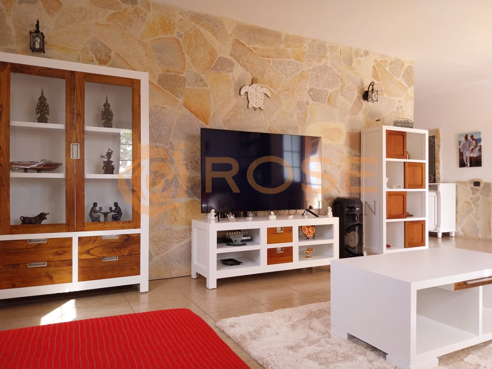 Área de estar con pared de piedra natural con carácter y concepto de almacenamiento bien pensado