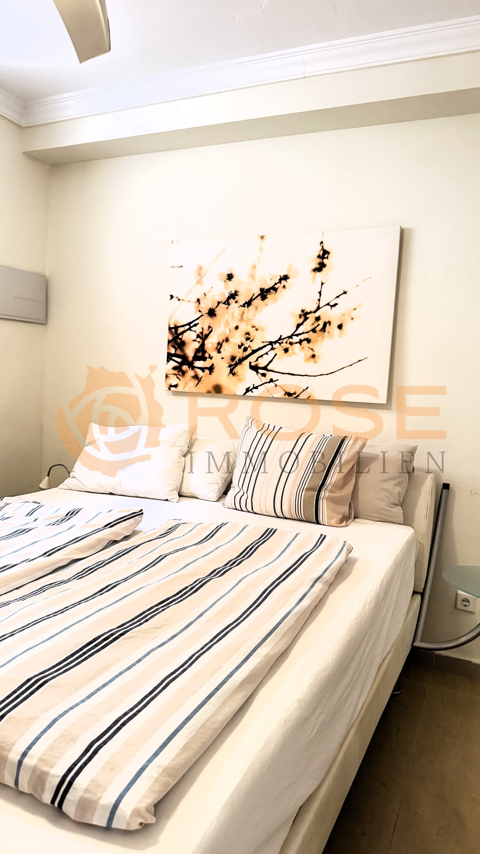 Dormitorio luminoso con vigas en el techo y nichos empotrados en la pared, comodidad funcional con almacenamiento inteligente