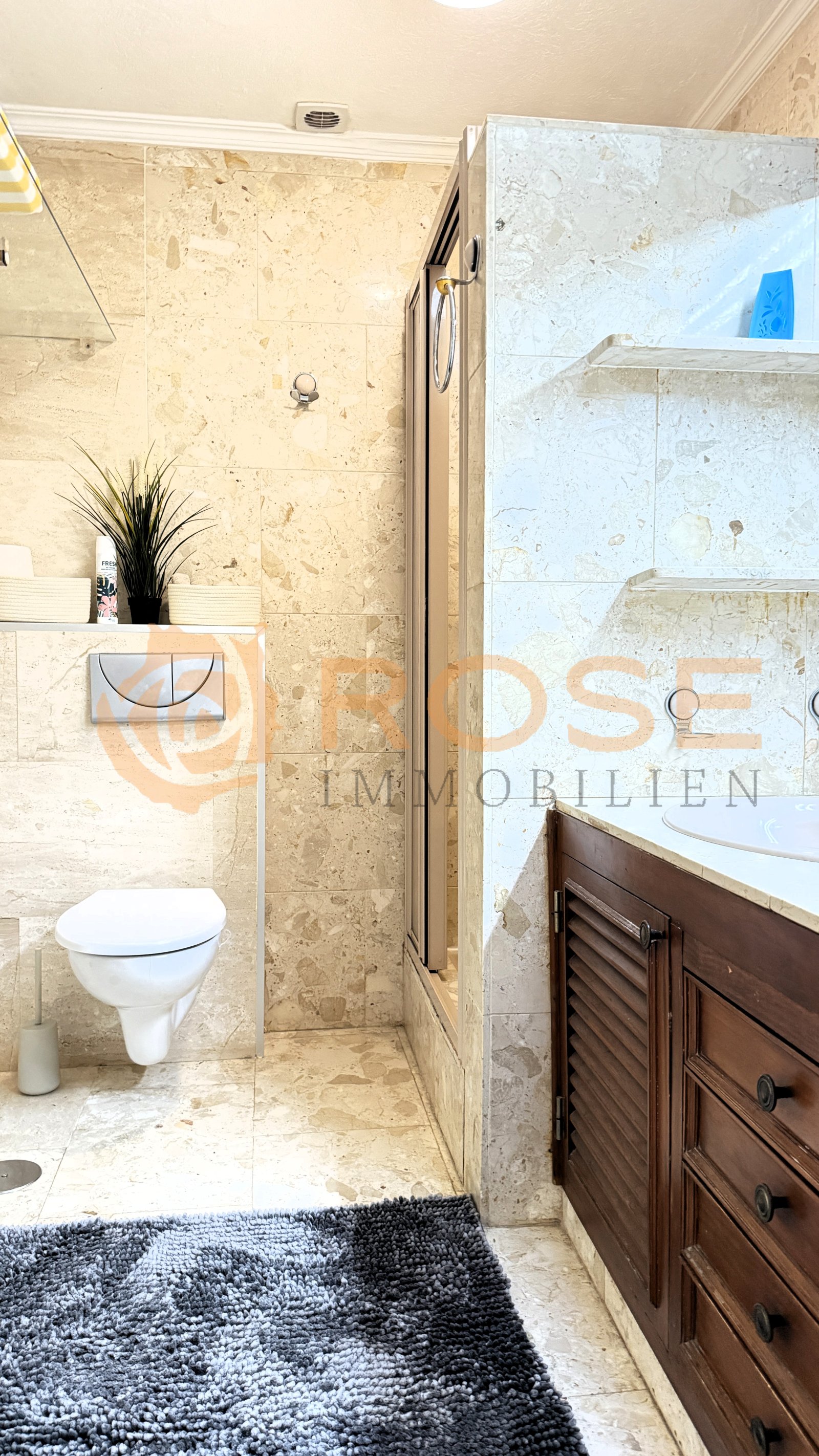 Baño de lujo con elegancia en piedra natural y ducha sin marco: el diseño moderno de bienestar combina materiales atemporales