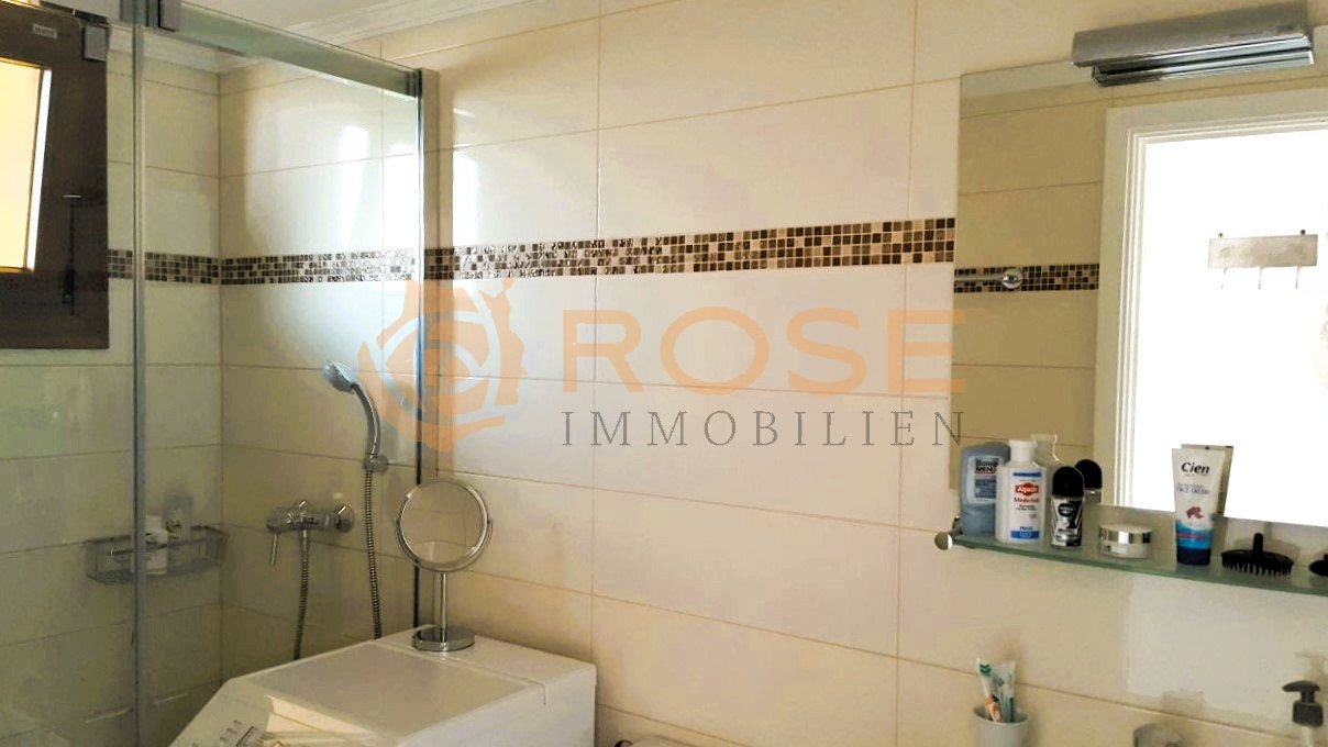 Baño moderno con ducha a nivel del suelo, acentos de azulejos de mosaico y superficies de almacenamiento prácticas. Baño moderno con ducha a nivel del suelo, acentos de azulejos de mosaico y superficies de almacenamiento prácticas.