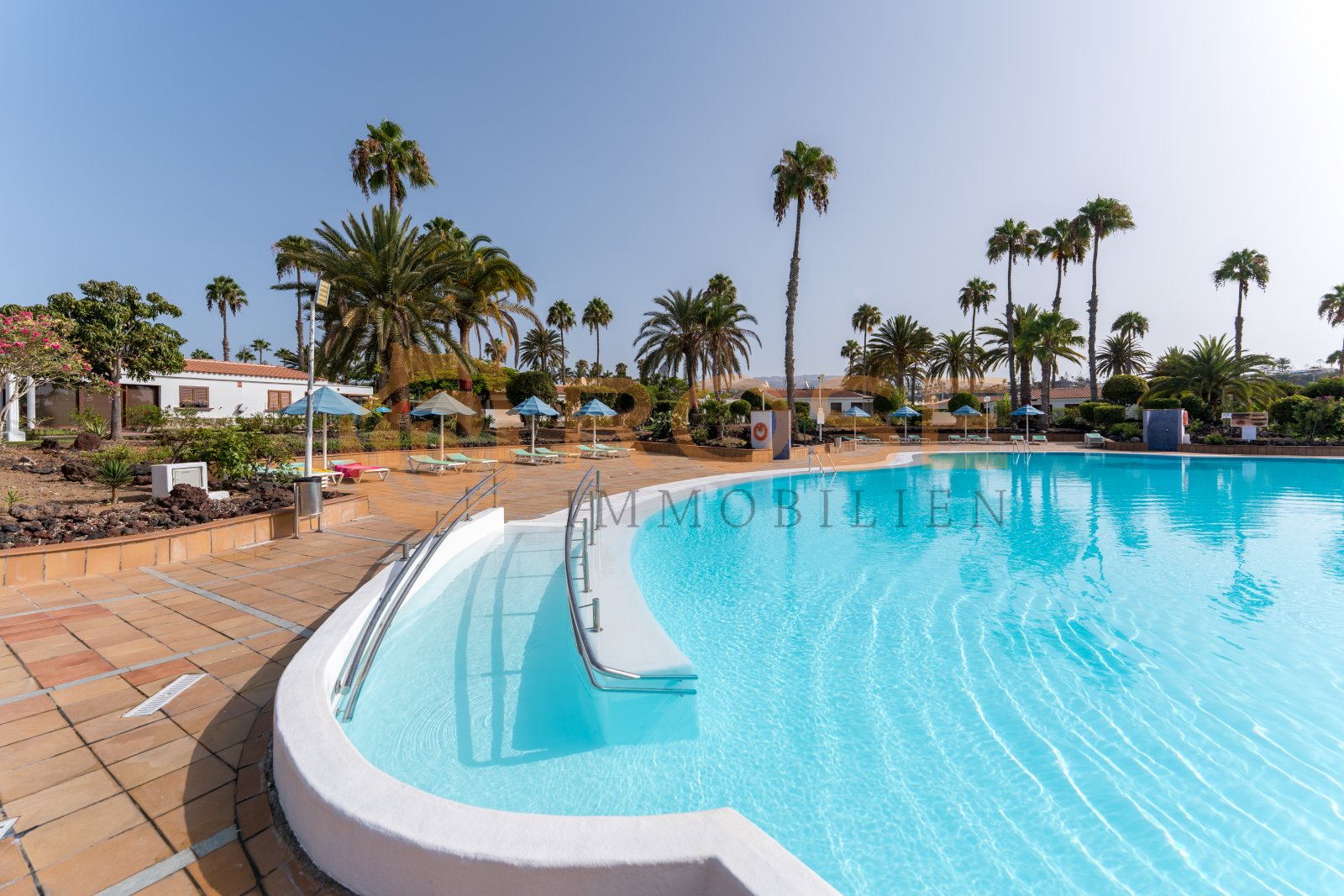 Piscina comunitaria con un diseño de piscina acogedor y una infraestructura de ocio completa Piscina comunitaria con un diseño de piscina acogedor y una infraestructura de ocio completa