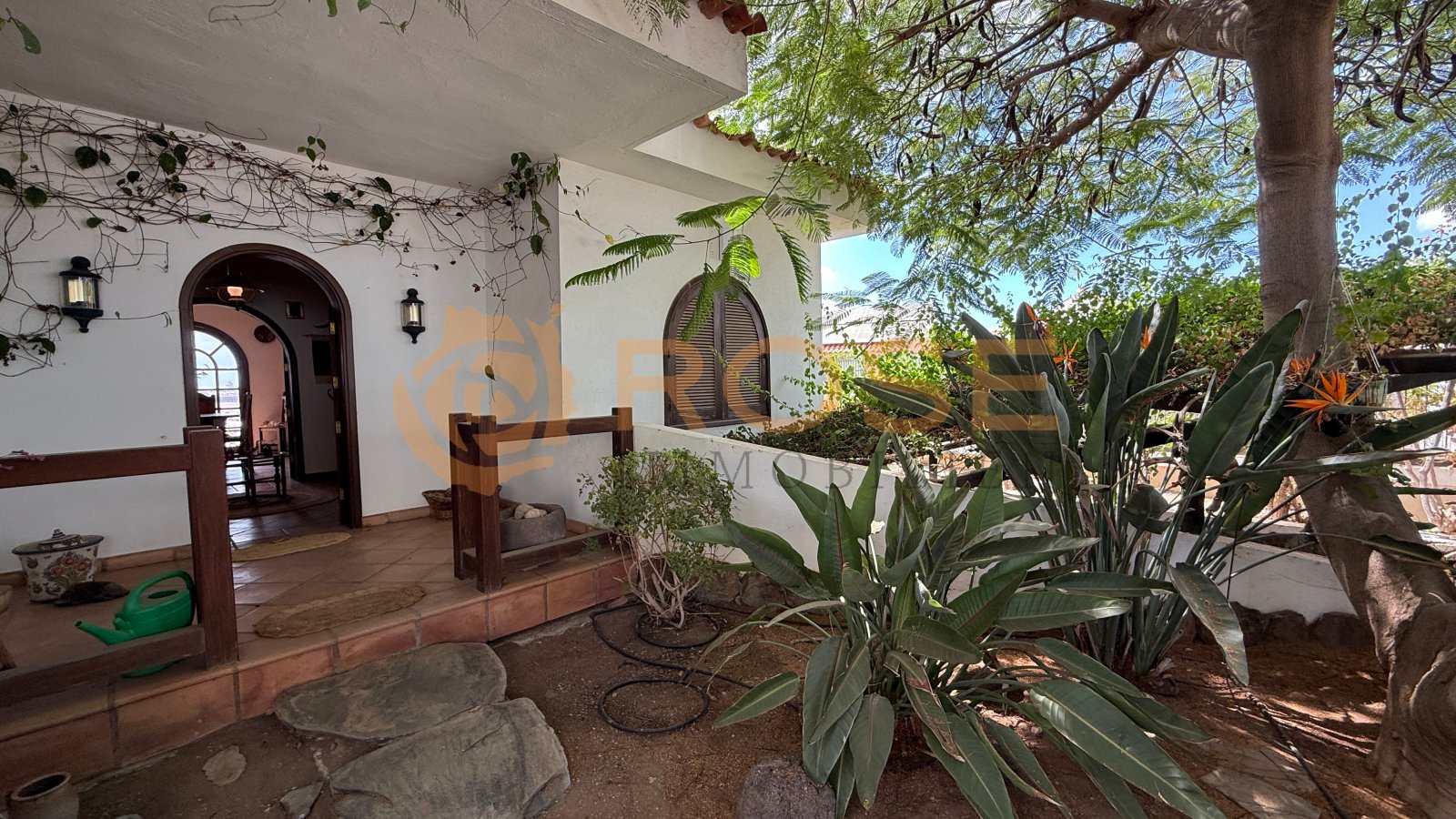 Veranda cubierta con arcos rústicos y acceso directo al jardín