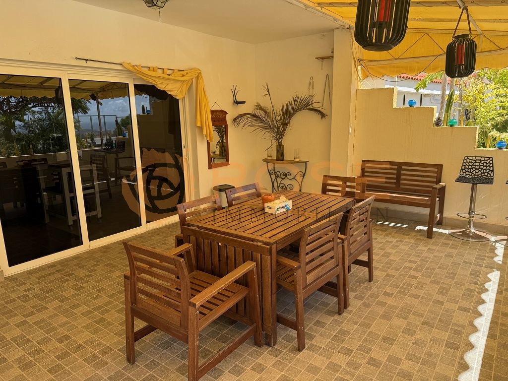 Espace de vie couvert avec une structure ouverte et un accès direct à la terrasse extérieure.