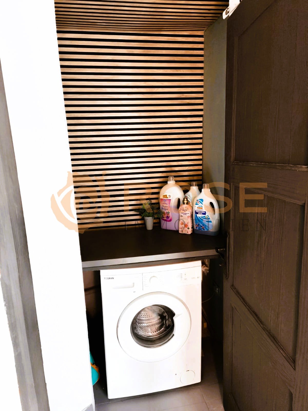 Lave-linge pratique avec un aménagement intelligent des surfaces de rangement et un plafond moderne