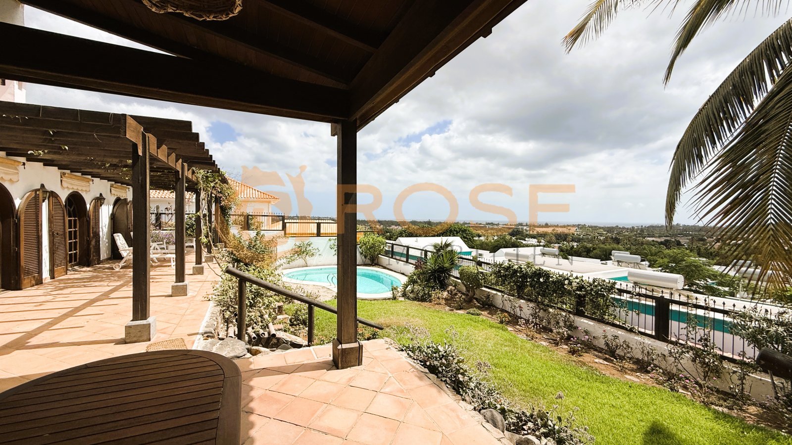 Terrasse couverte avec vue sur la piscine et structure élégante de colonnes